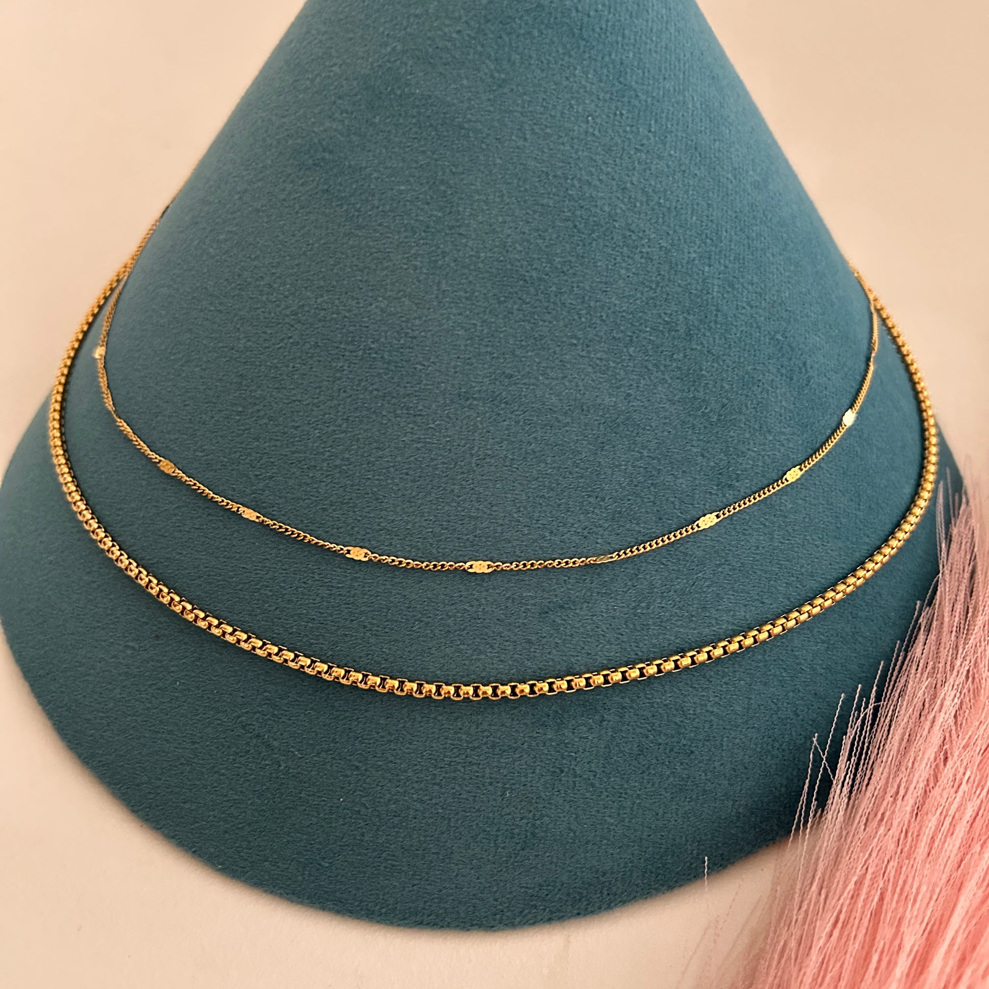 Layered gold waist band with slim top chain and thicker bottom chain combination.