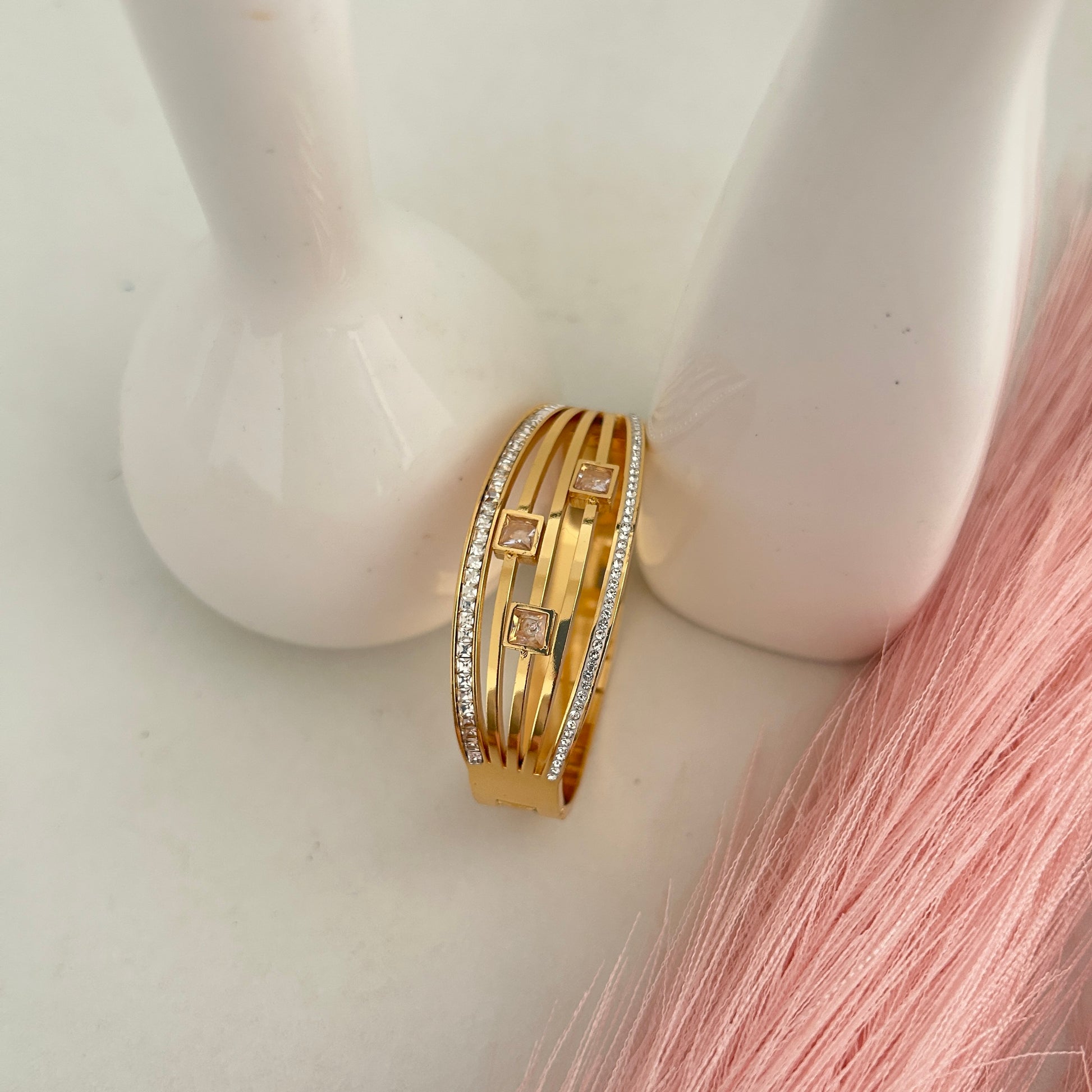 Gold layered bangle with three square crystal stones.