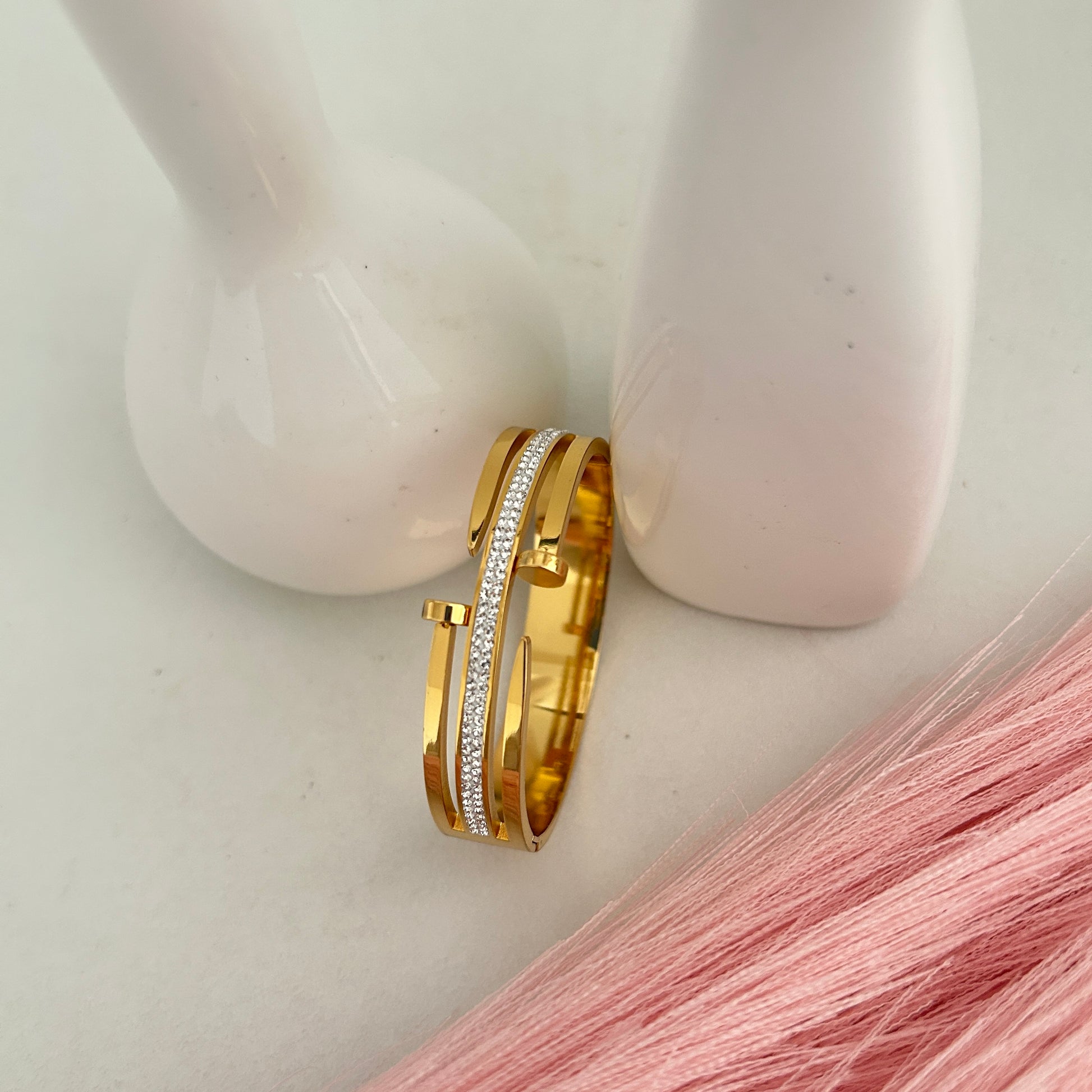 Open style gold bangle bracelet with crystal strip.