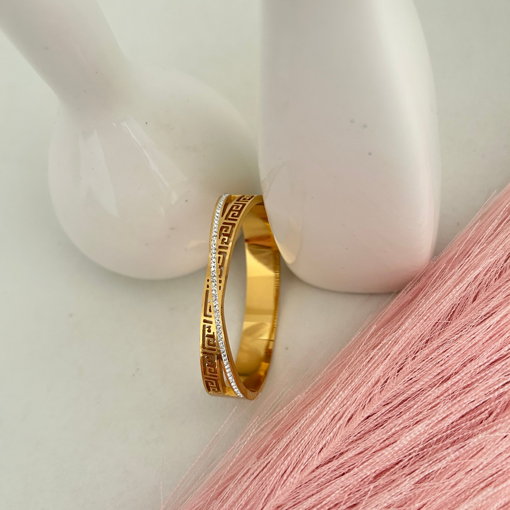 Gold engraved bangle with geometric Greek key pattern.