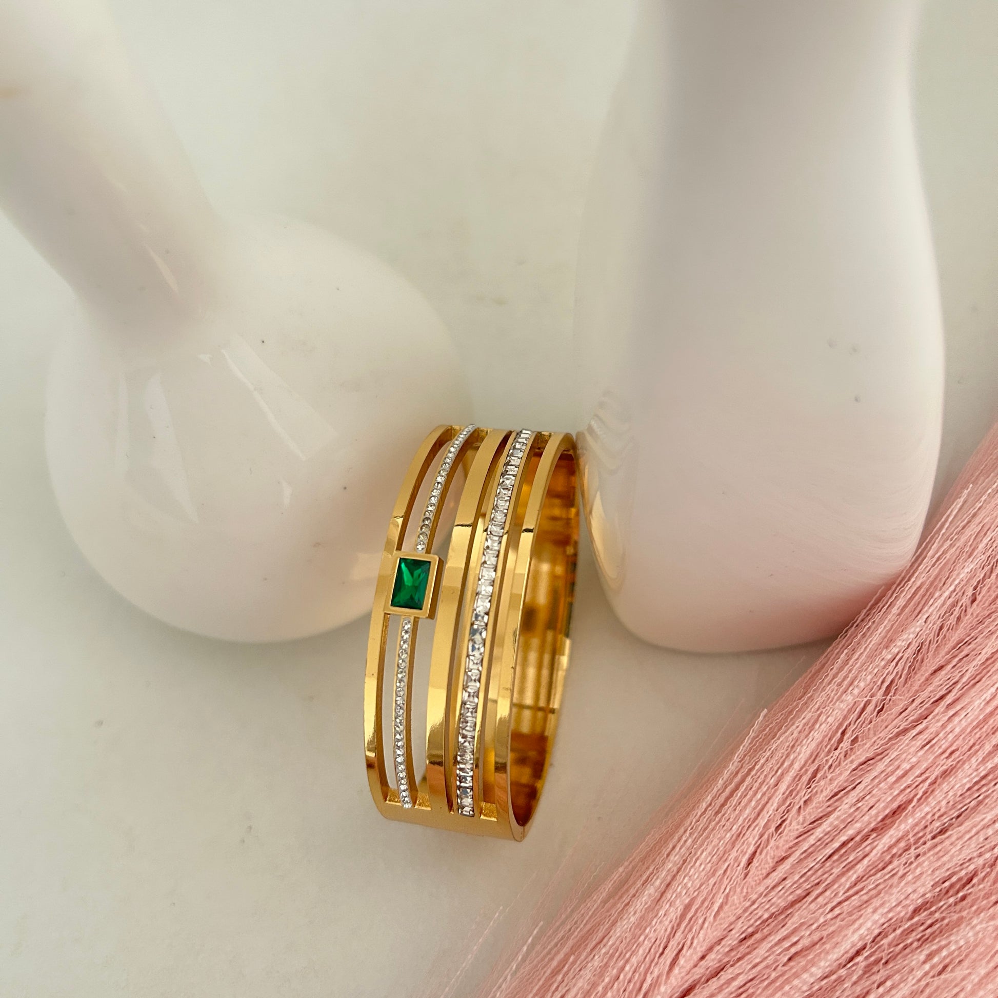 Gold bangle with green rectangular stone and crystal strips.