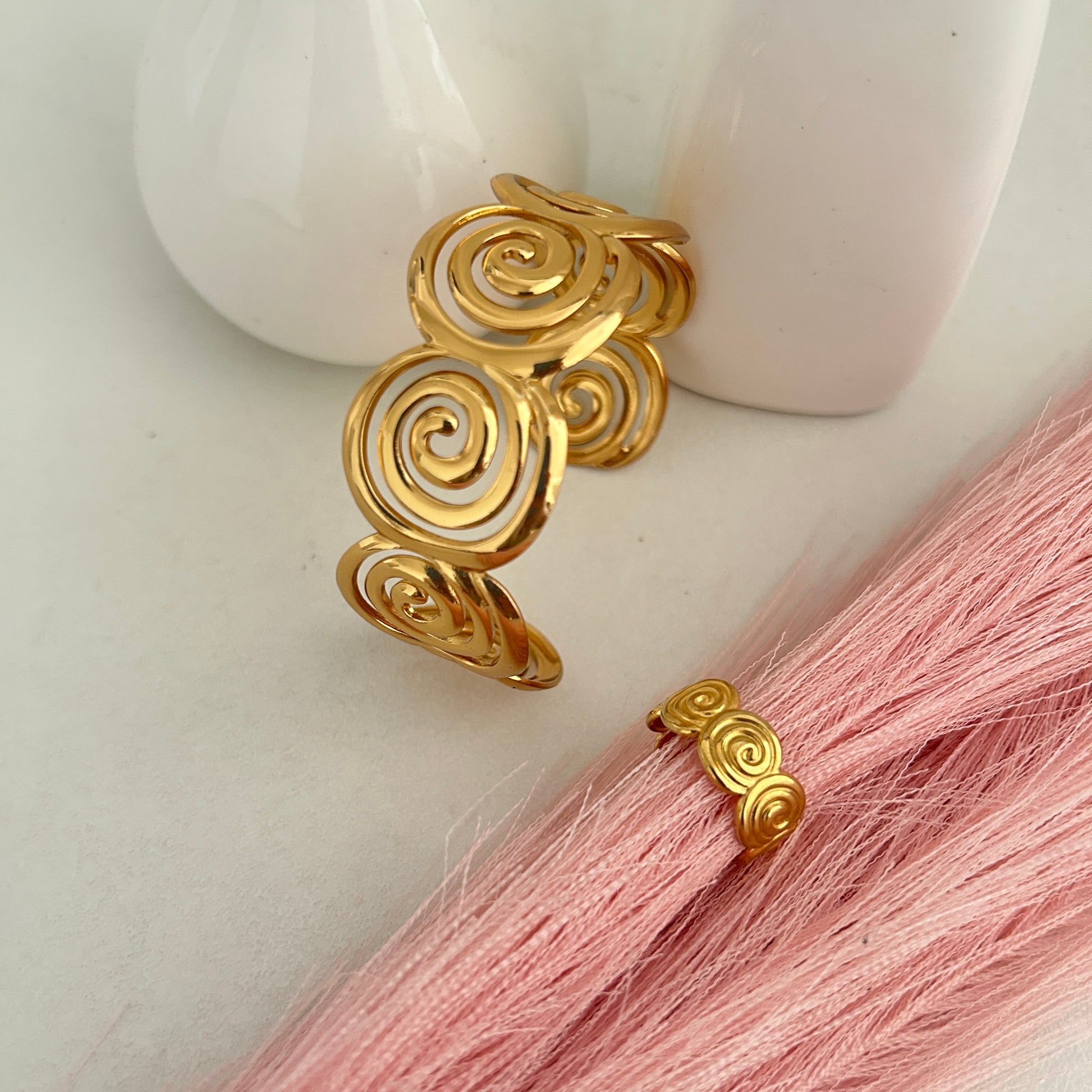 Gold spiral design cuff bracelet with matching spiral ring.