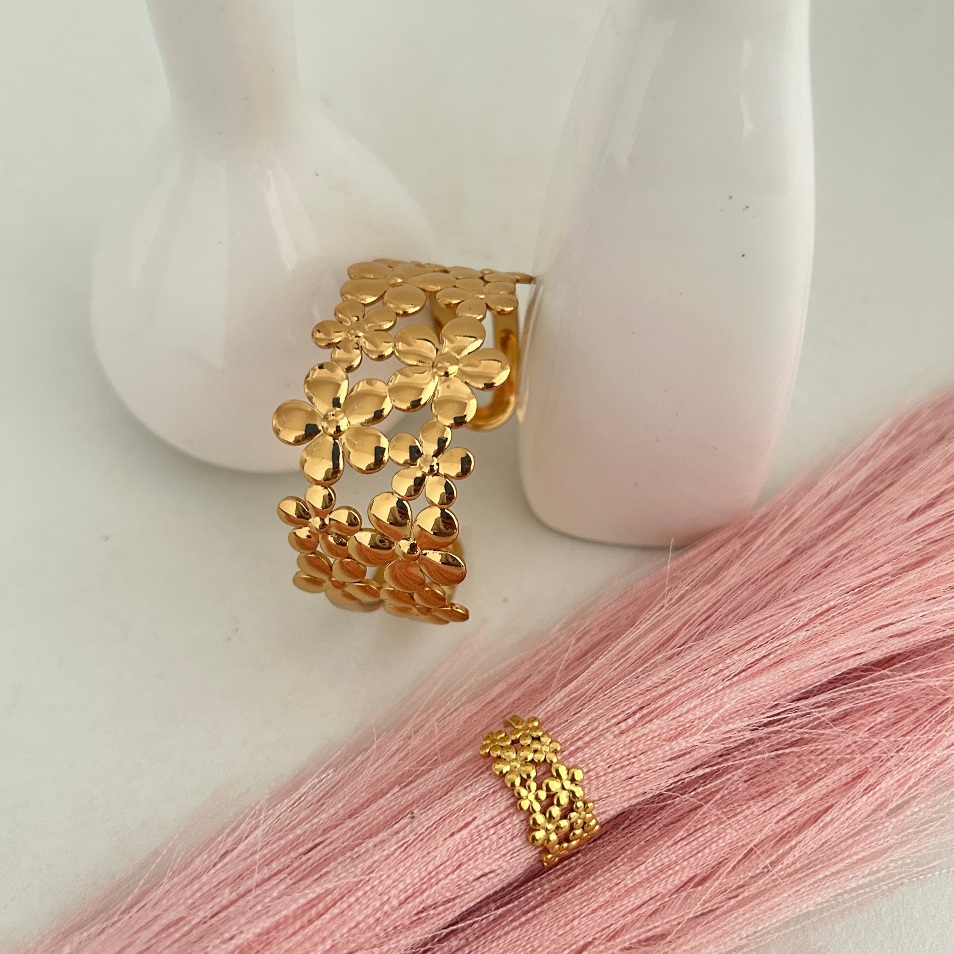 Wide gold floral cuff bracelet with matching flower ring.