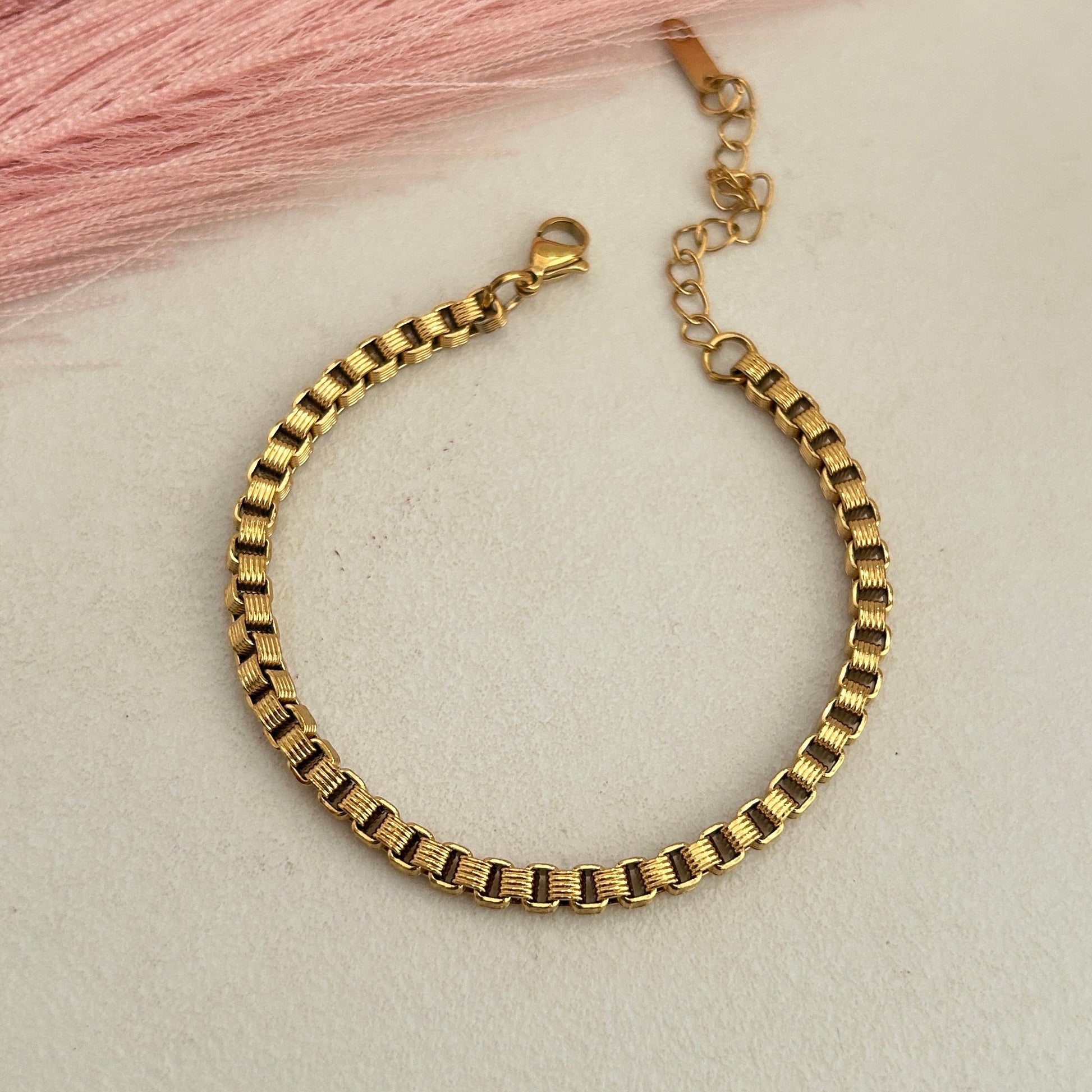 Gold box link bracelet with adjustable chain.