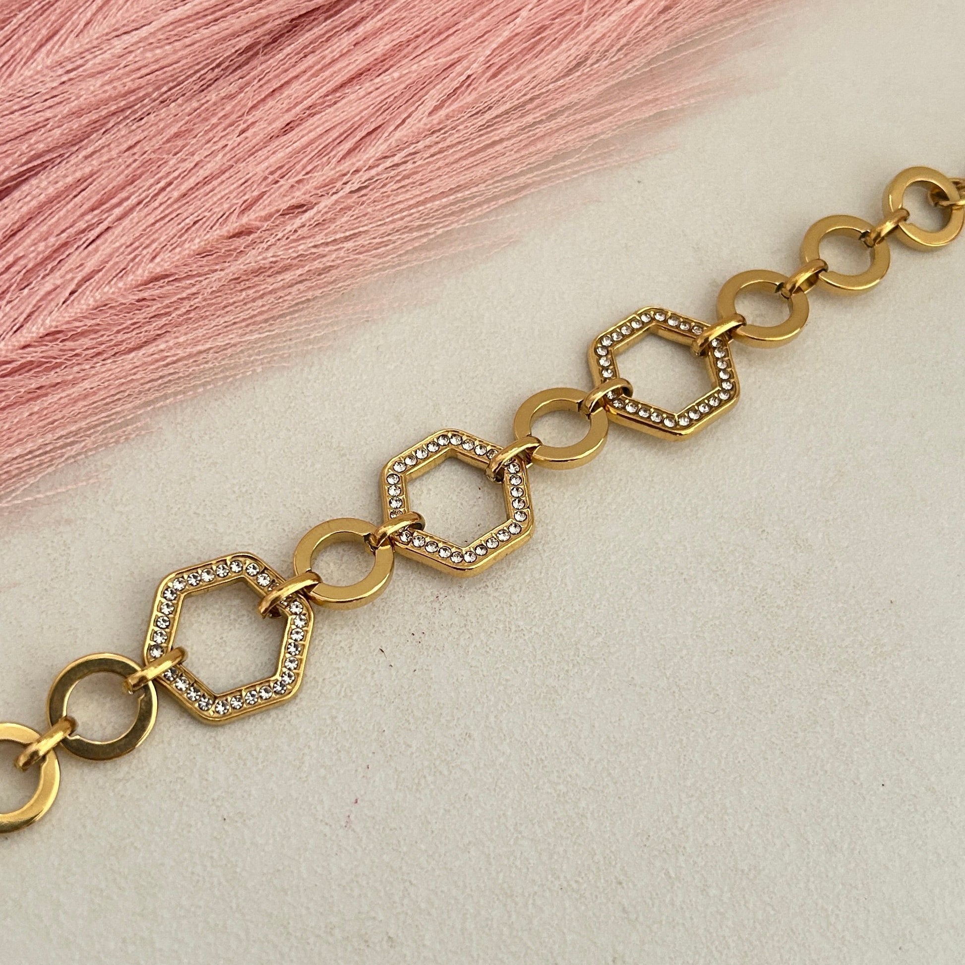 Gold bracelet with hexagon crystal link pattern.