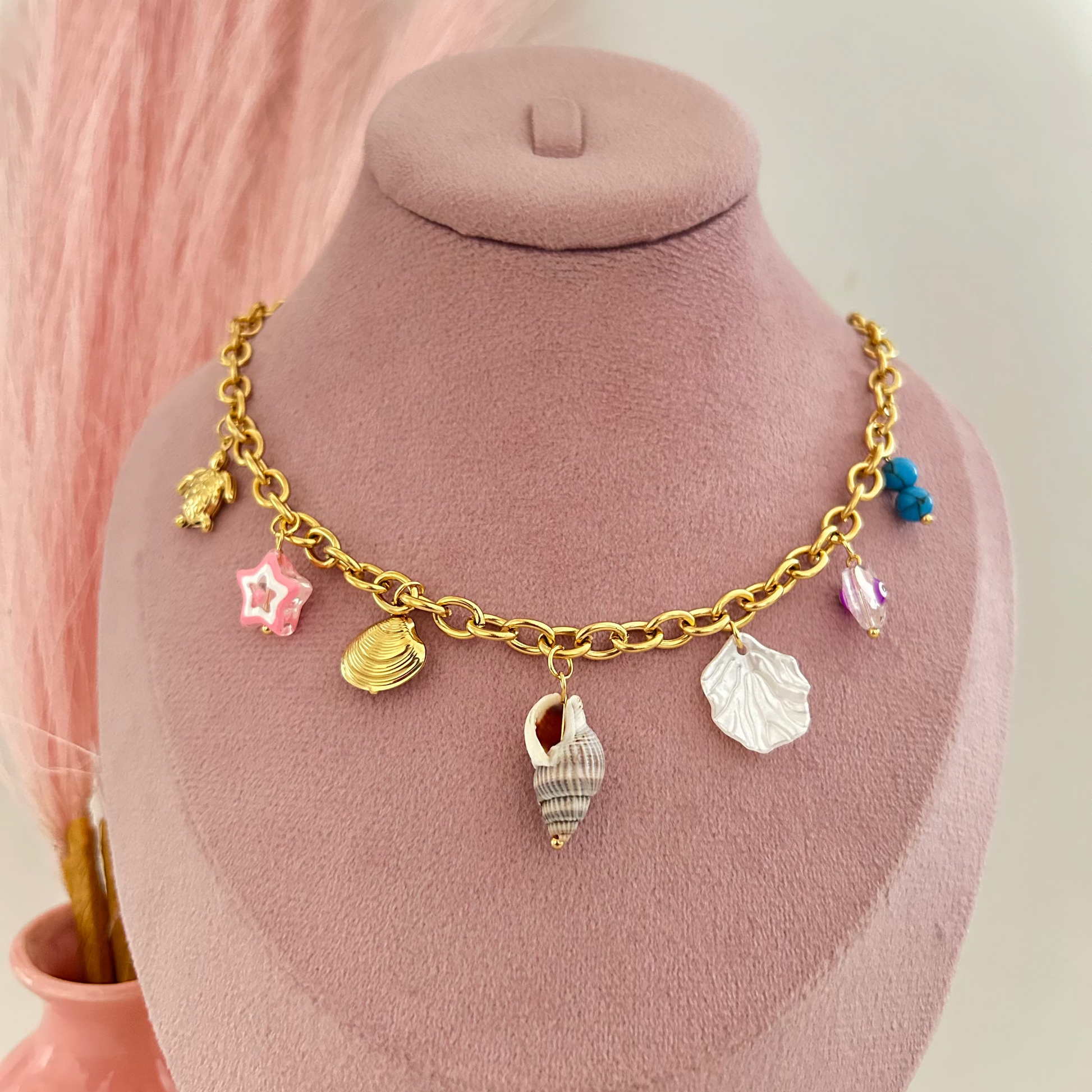 Gold chain necklace with shell and ocean themed charms.