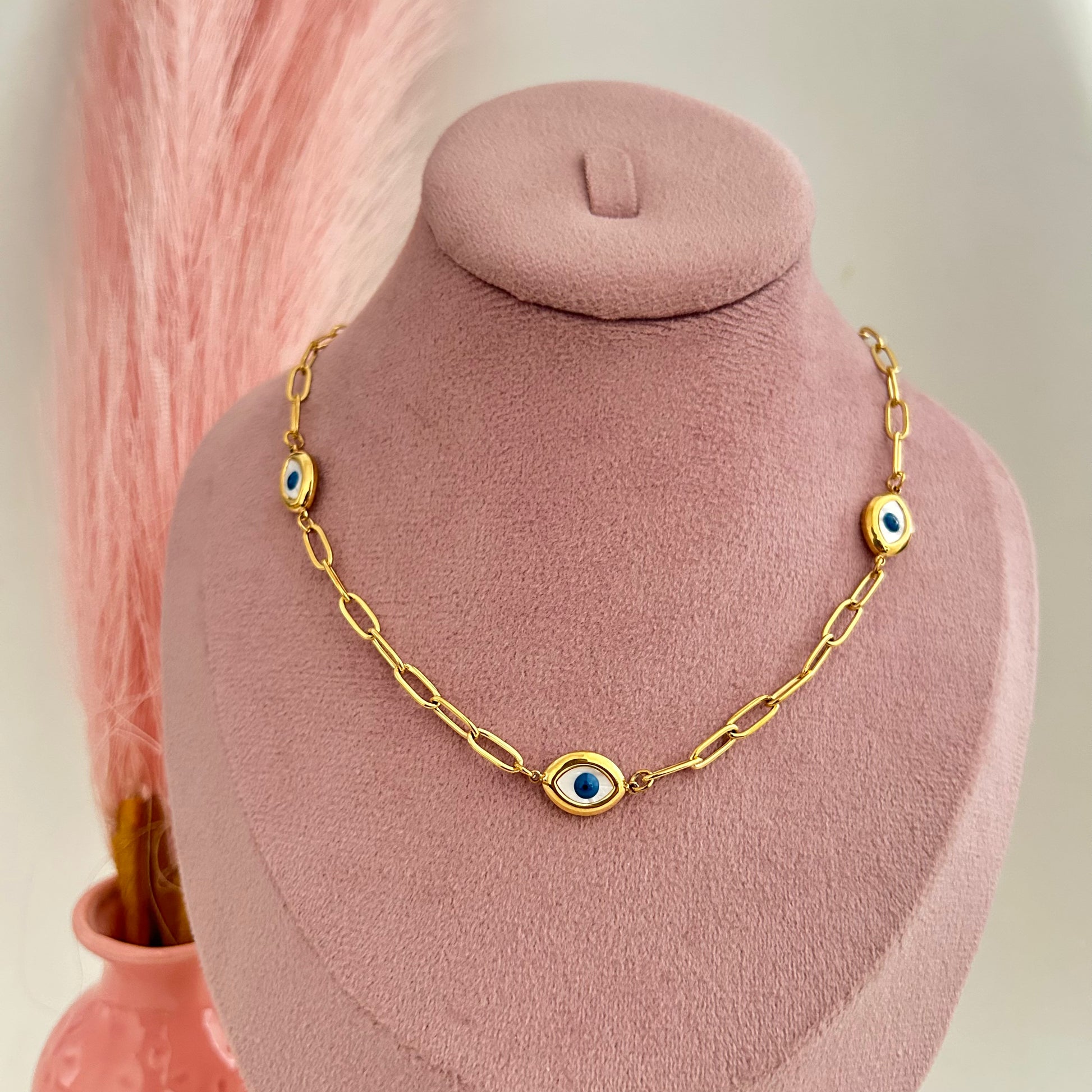 Chunky gold chain necklace with large evil eye charms displayed on bust