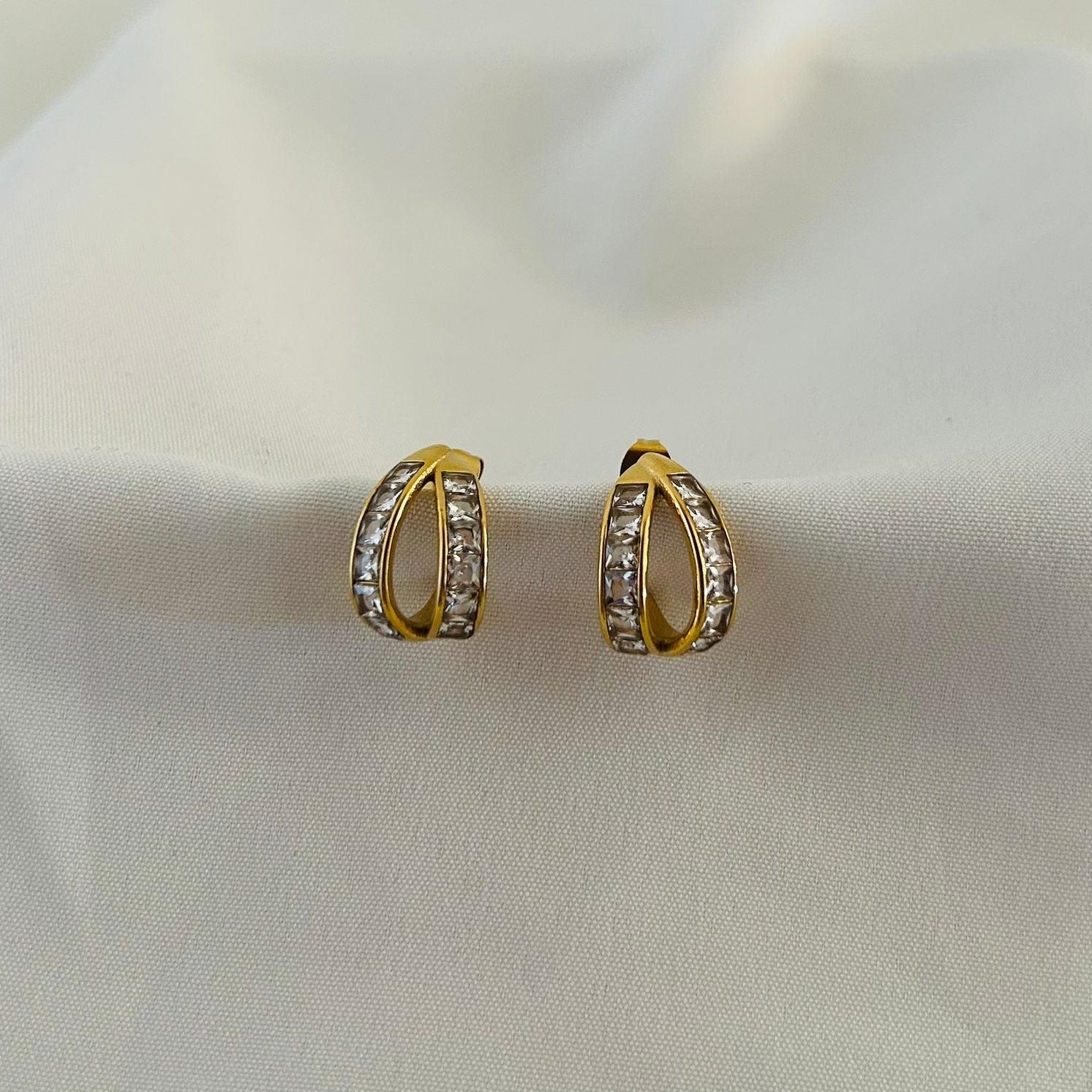 Modern gold hoops with dual curve and crystal detailing.