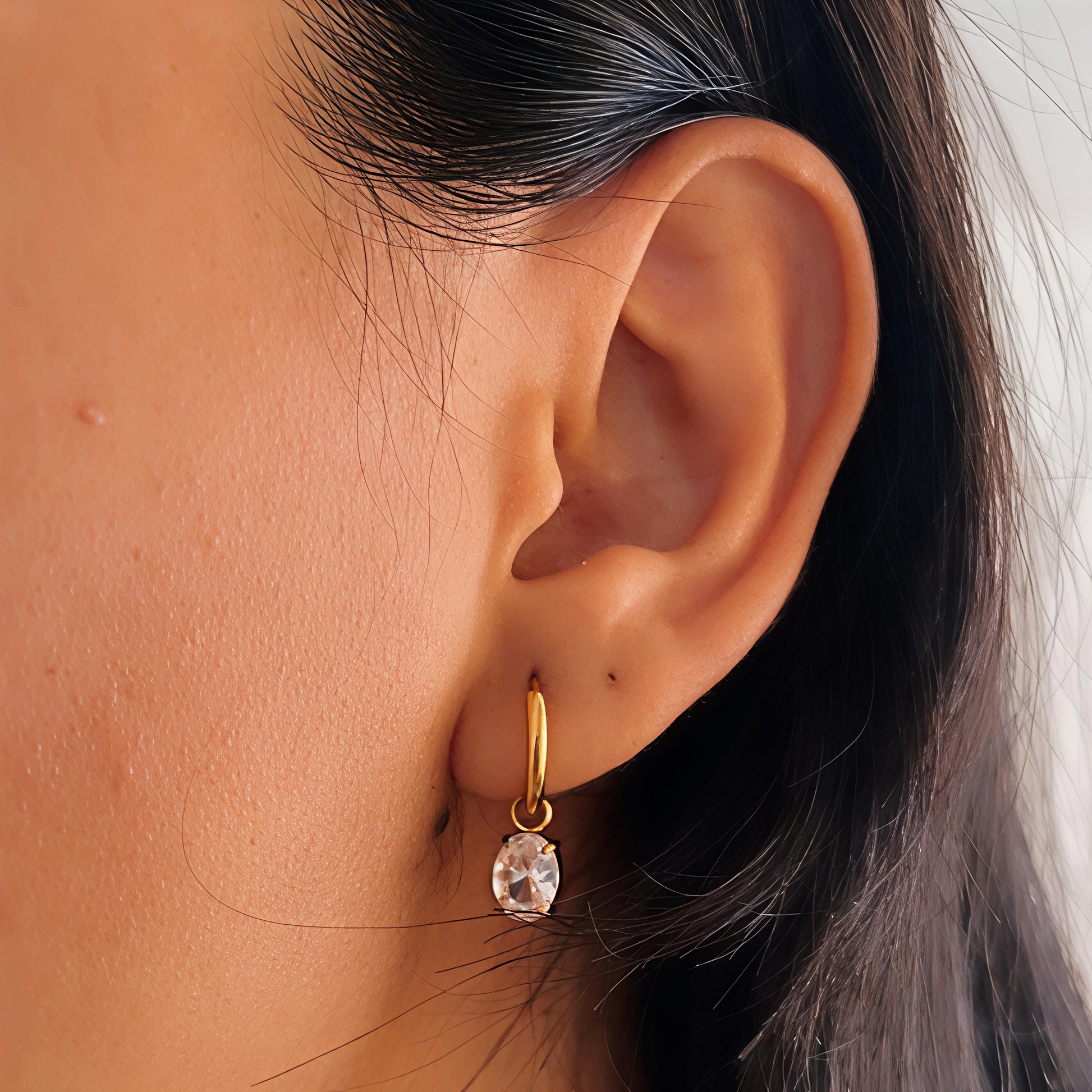 Small gold hoop earrings with hanging crystal stones
