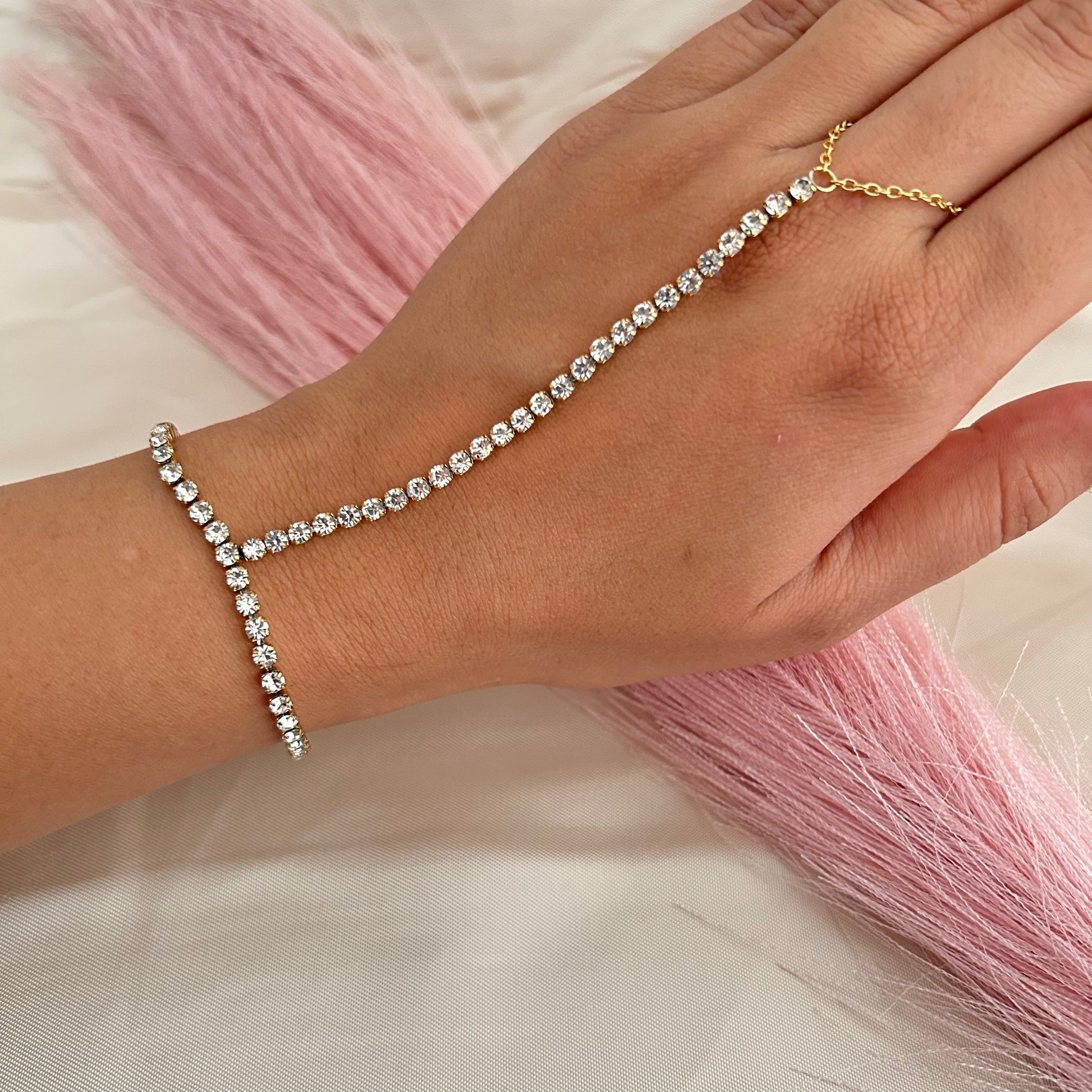 Hand chain bracelet with sparkling stones connecting wrist to finger
