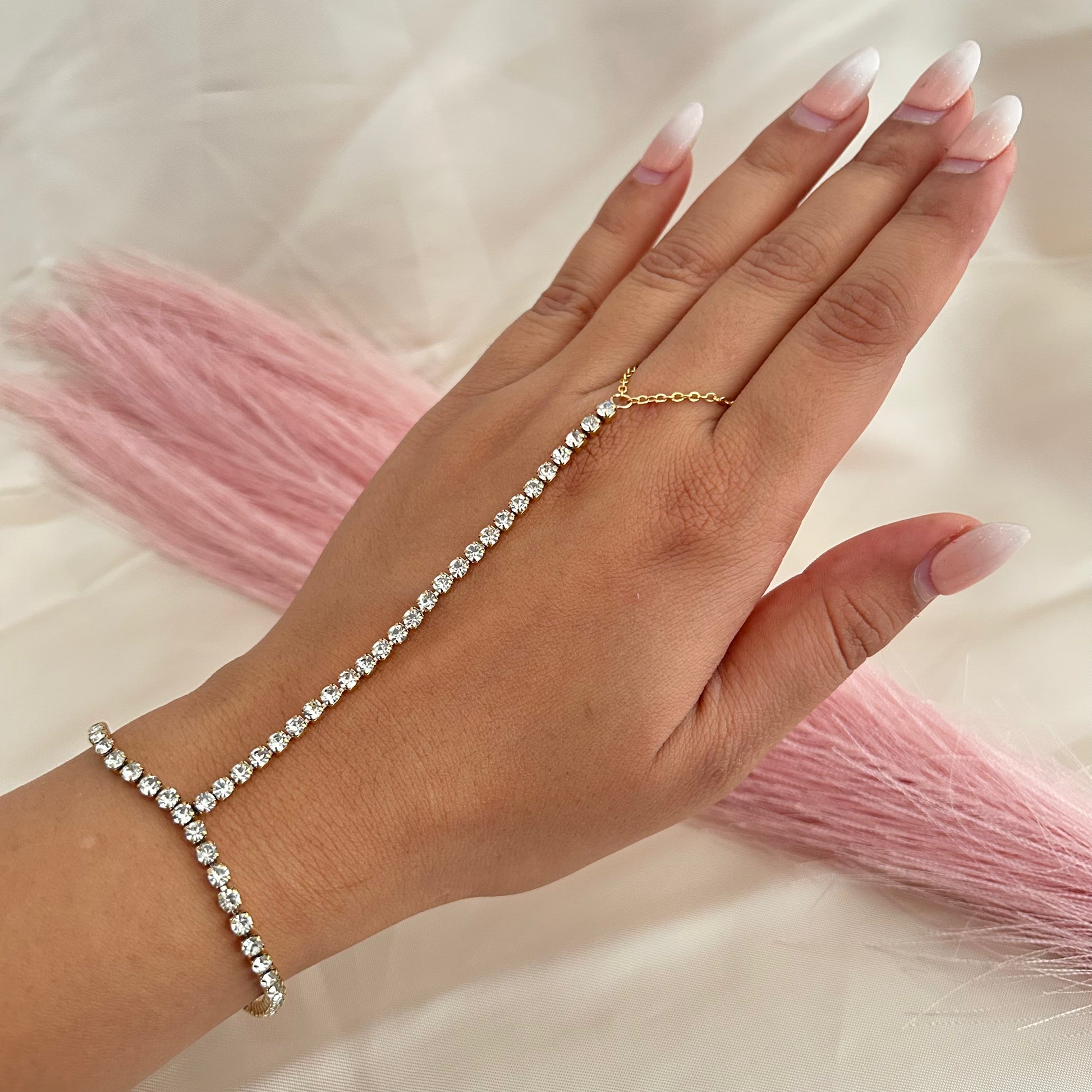 Hand chain bracelet with sparkling stones connecting wrist to finger