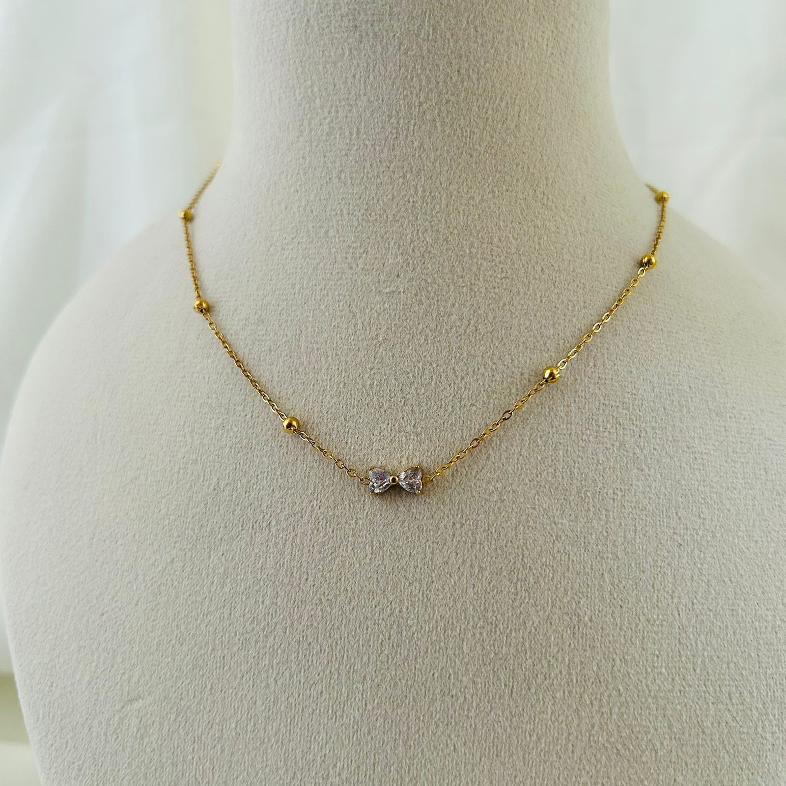 Minimal gold chain necklace with bow crystal stones.