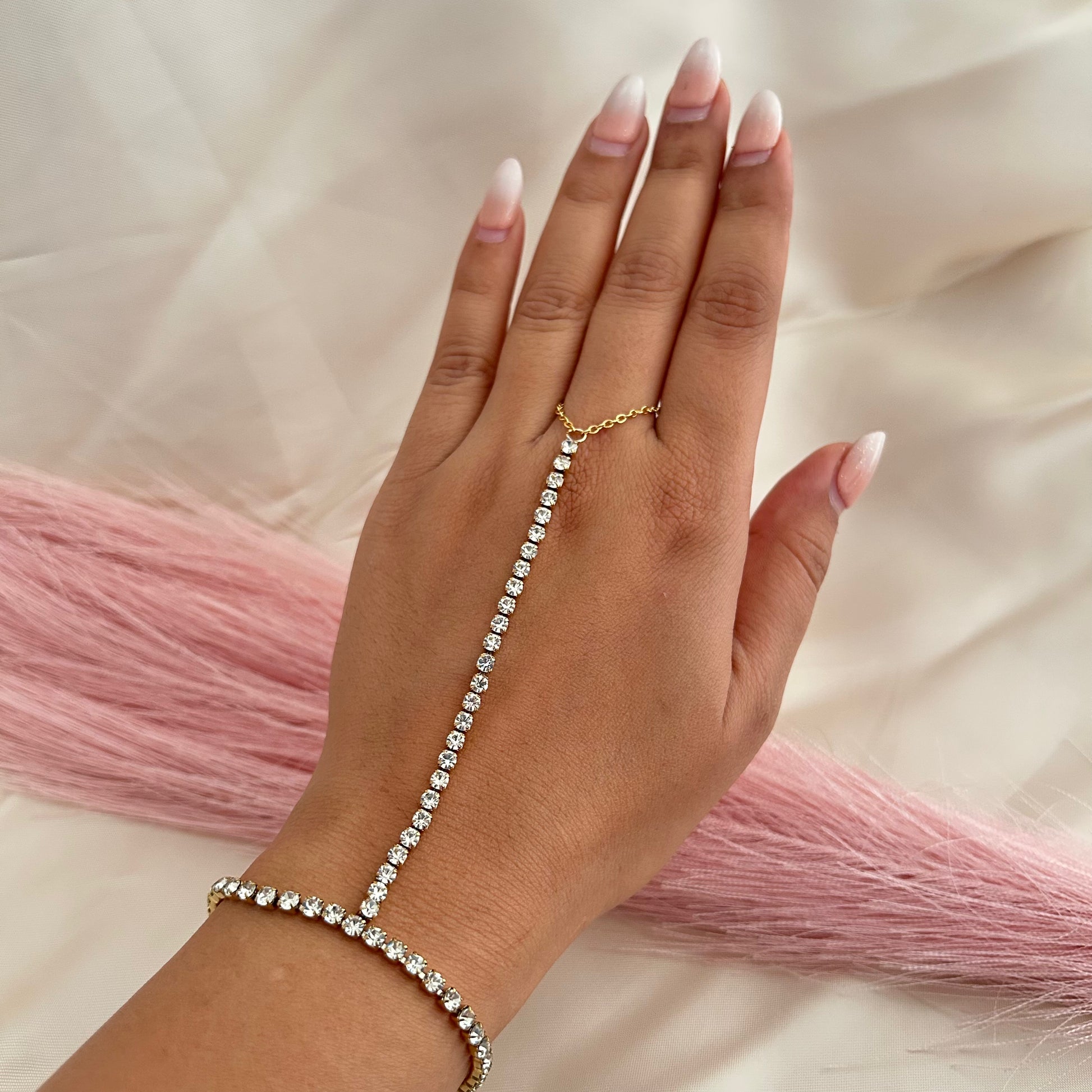 Hand chain bracelet with sparkling stones connecting wrist to finger